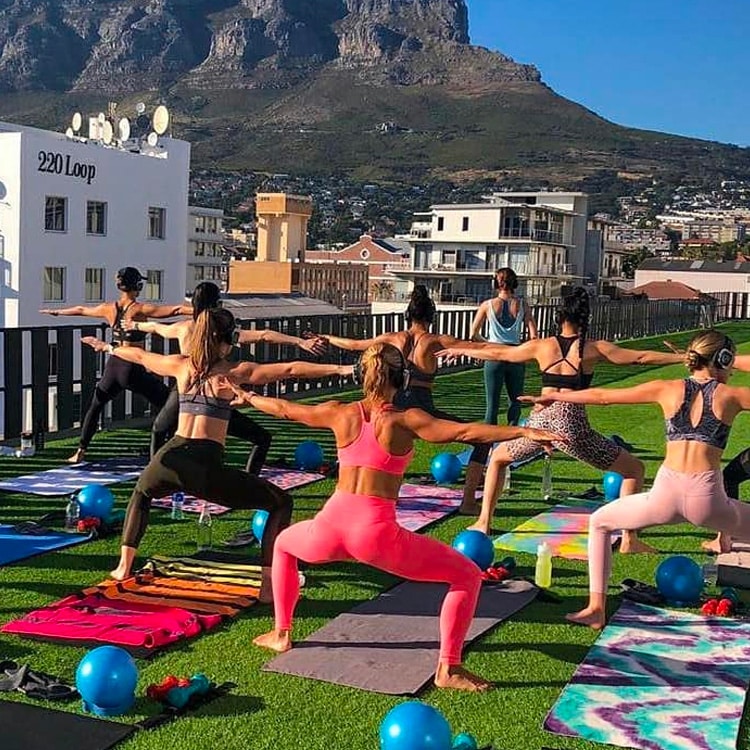 palestra-aperta Fitness-Stunde im Freien auf einer Terrasse mit kabellosen Kopfhörern